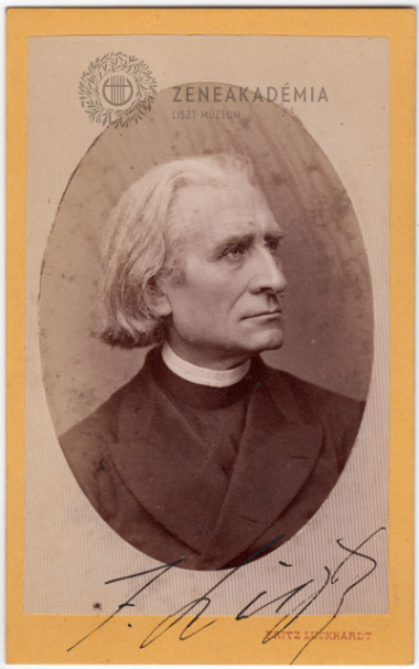 Yellow visit card with a picture in black and white taken in 1871. It represents Liszt wearing a black cassock and a black coat. He looks toward his left. At the bottom of the picture, the name of the photographer. Liszt signed the card.